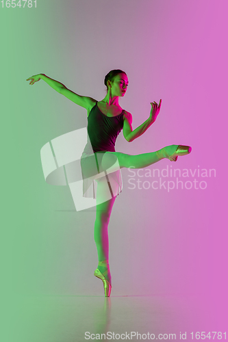 Image of Young and graceful ballet dancer isolated on gradient pink-green studio background in neon light. Art in motion