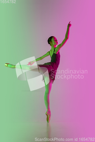 Image of Young and graceful ballet dancer isolated on gradient pink-green studio background in neon light. Art in motion