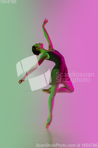 Image of Young and graceful ballet dancer isolated on gradient pink-green studio background in neon light. Art in motion