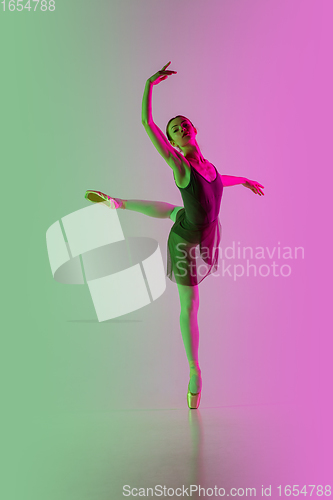 Image of Young and graceful ballet dancer isolated on gradient pink-green studio background in neon light. Art in motion