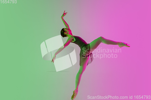 Image of Young and graceful ballet dancer isolated on gradient pink-green studio background in neon light. Art in motion