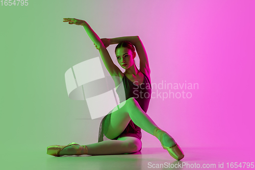 Image of Young and graceful ballet dancer isolated on gradient pink-green studio background in neon light. Art in motion