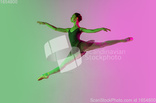 Image of Young and graceful ballet dancer isolated on gradient pink-green studio background in neon light. Art in motion