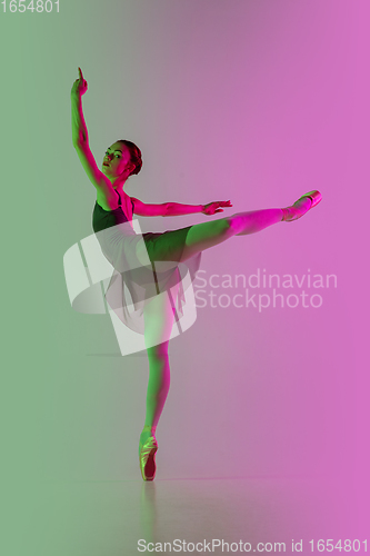 Image of Young and graceful ballet dancer isolated on gradient pink-green studio background in neon light. Art in motion