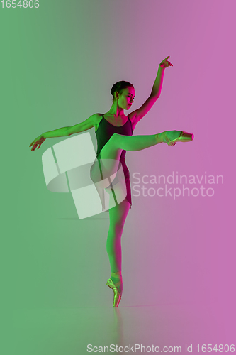 Image of Young and graceful ballet dancer isolated on gradient pink-green studio background in neon light. Art in motion