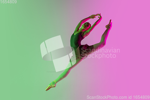 Image of Young and graceful ballet dancer isolated on gradient pink-green studio background in neon light. Art in motion