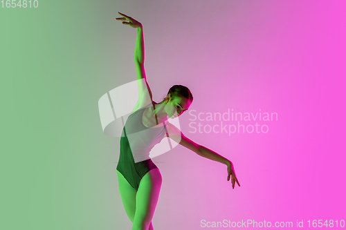 Image of Young and graceful ballet dancer isolated on gradient pink-green studio background in neon light. Art in motion