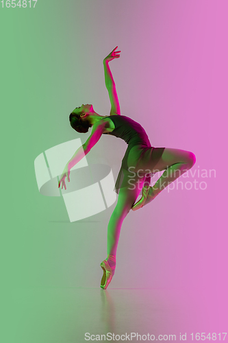 Image of Young and graceful ballet dancer isolated on gradient pink-green studio background in neon light. Art in motion