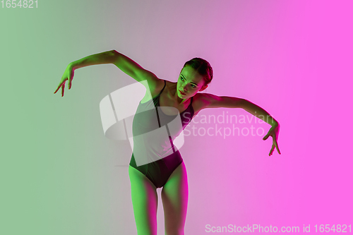 Image of Young and graceful ballet dancer isolated on gradient pink-green studio background in neon light. Art in motion
