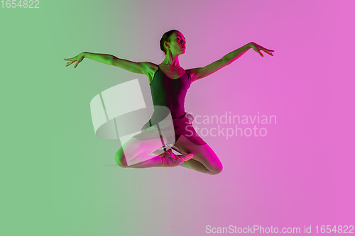 Image of Young and graceful ballet dancer isolated on gradient pink-green studio background in neon light. Art in motion