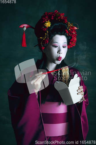 Image of Young japanese woman as geisha on dark green background. Retro style, comparison of eras concept.