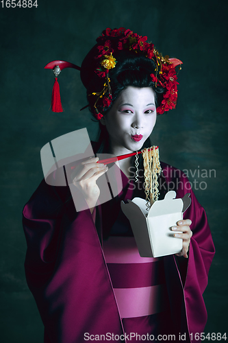 Image of Young japanese woman as geisha on dark green background. Retro style, comparison of eras concept.