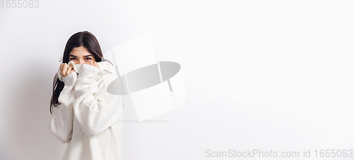 Image of Portrait of beautiful woman isolated on white studio background. Comfort, warm in winter concept