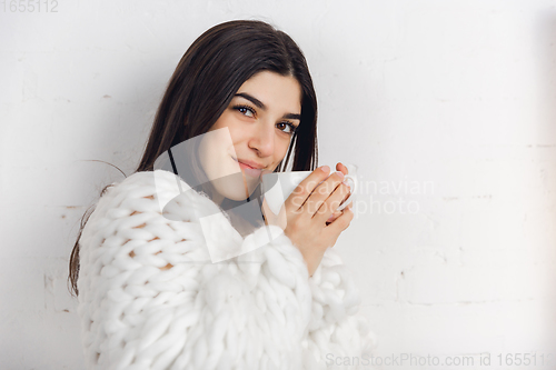 Image of Portrait of beautiful woman isolated on white studio background. Comfort, warm in winter concept