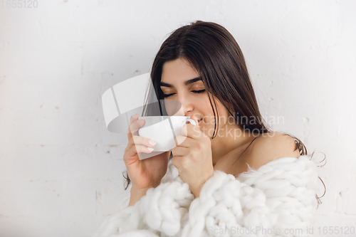 Image of Portrait of beautiful woman isolated on white studio background. Comfort, warm in winter concept