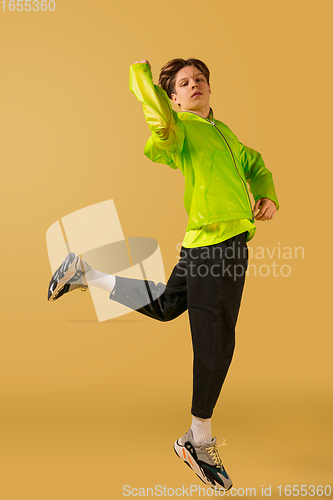 Image of Old-school fashioned young man dancing isolated on yellow background