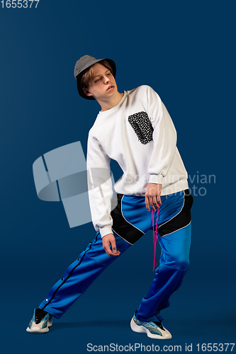 Image of Old-school fashioned young man dancing isolated on blue background