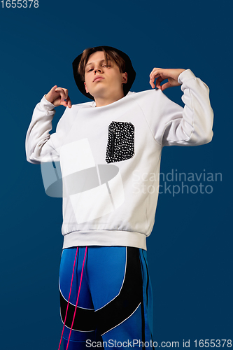 Image of Old-school fashioned young man dancing isolated on blue background