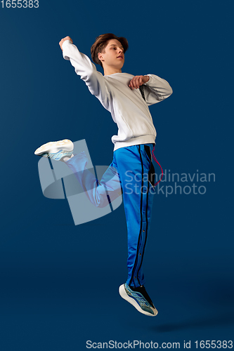 Image of Old-school fashioned young man dancing isolated on blue background