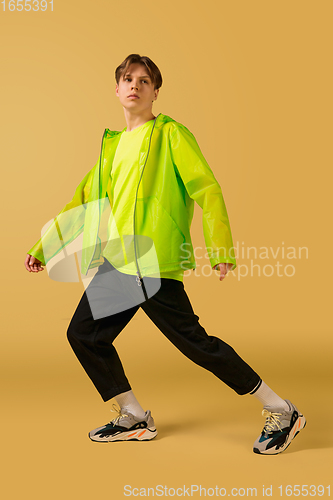 Image of Old-school fashioned young man dancing isolated on yellow background