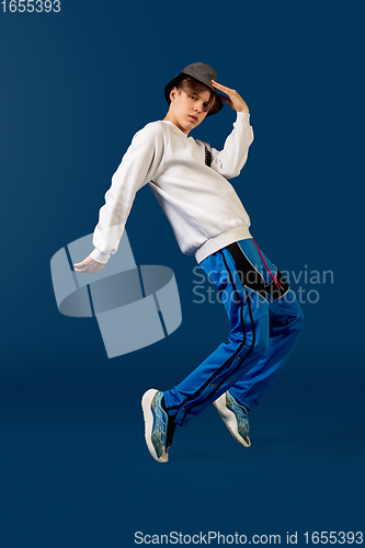 Image of Old-school fashioned young man dancing isolated on blue background