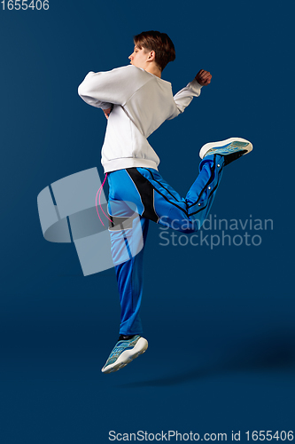 Image of Old-school fashioned young man dancing isolated on blue background