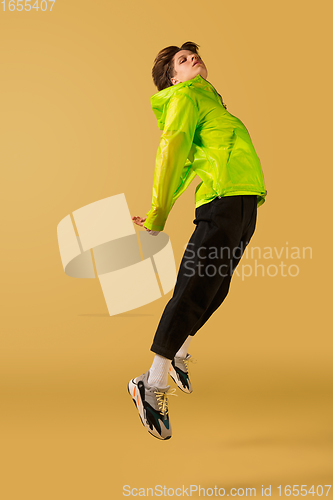 Image of Old-school fashioned young man dancing isolated on yellow background