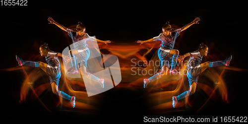 Image of Football or soccer player on black studio background in mixed light with strobe light, mirror effect, reflection with fire flames