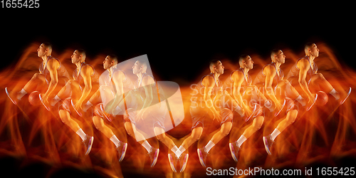 Image of Young purposeful basketball player training in action isolated on black background with fire flames. Mirror, strobe light effect, reflection