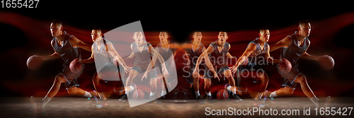 Image of Young purposeful basketball player training in action isolated on black background with fire flames. Mirror, strobe light effect, reflection