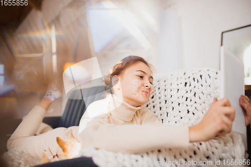 Image of Young woman enjoying her domestic life. Home comfort, winter and holidays time