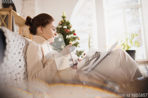 Image of Young woman enjoying her domestic life. Home comfort, winter and holidays time