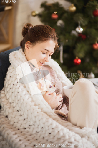 Image of Young woman enjoying her domestic life. Home comfort, winter and holidays time