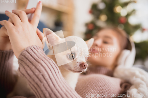 Image of Young woman enjoying her domestic life. Home comfort, winter and holidays time