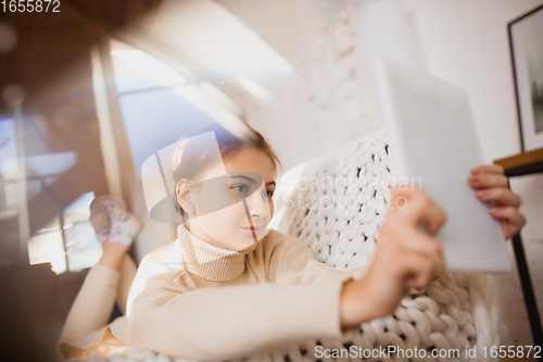 Image of Young woman enjoying her domestic life. Home comfort, winter and holidays time