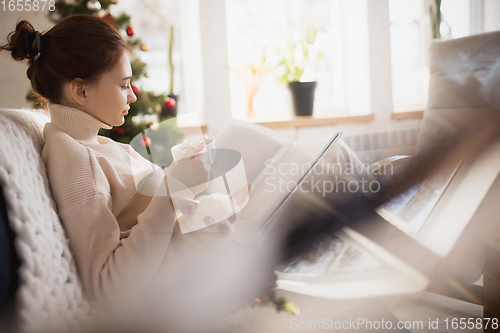 Image of Young woman enjoying her domestic life. Home comfort, winter and holidays time