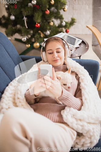 Image of Young woman enjoying her domestic life. Home comfort, winter and holidays time