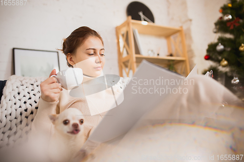 Image of Young woman enjoying her domestic life. Home comfort, winter and holidays time