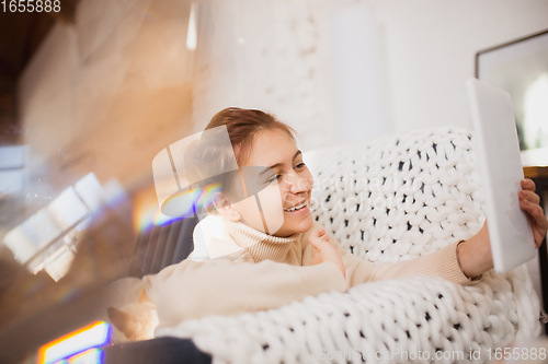 Image of Young woman enjoying her domestic life. Home comfort, winter and holidays time