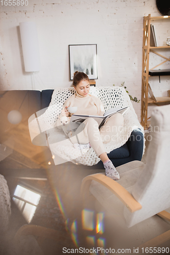 Image of Young woman enjoying her domestic life. Home comfort, winter and holidays time