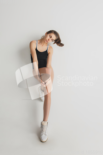 Image of Beautiful young woman\'s portrait isolated on grey studio background. Having fun, happy, full length