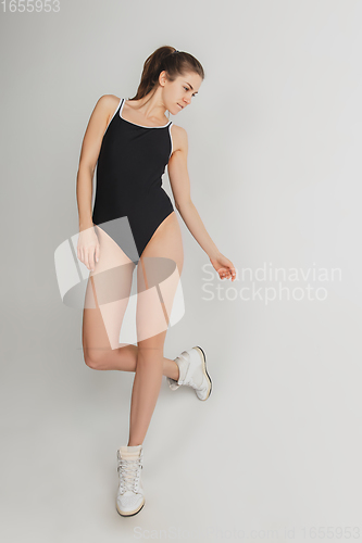 Image of Beautiful young woman\'s portrait isolated on grey studio background. Having fun, happy, full length