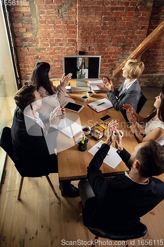 Image of Young people talking, working during videoconference with colleagues at office or living room