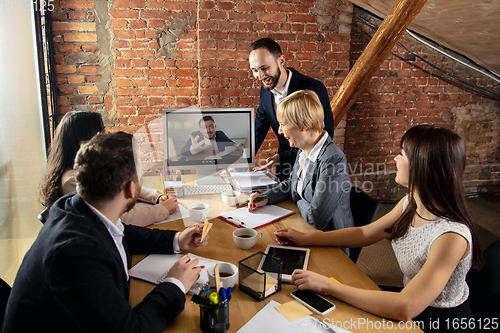 Image of Young people talking, working during videoconference with colleagues at office or living room
