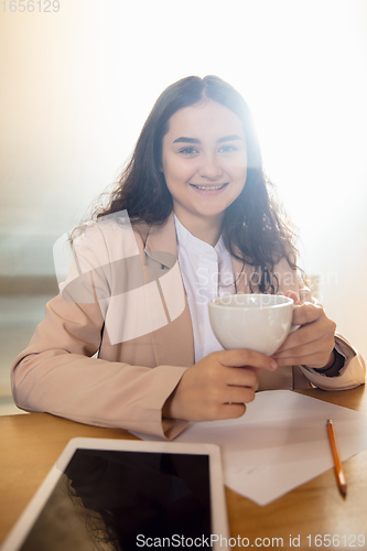 Image of Young woman talking, working during videoconference with colleagues at home office