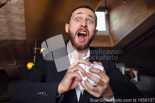 Image of Young man talking, working during videoconference with colleagues at home office