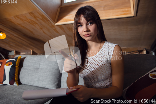 Image of Young woman talking, working during videoconference with colleagues at home office