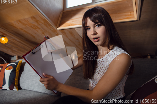 Image of Young woman talking, working during videoconference with colleagues at home office