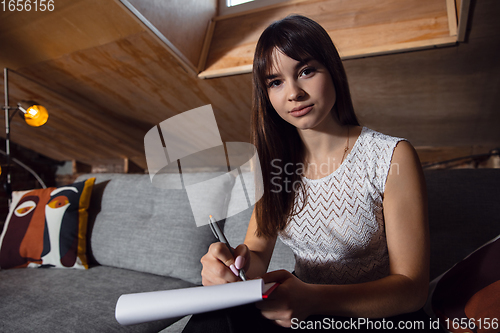 Image of Young woman talking, working during videoconference with colleagues at home office