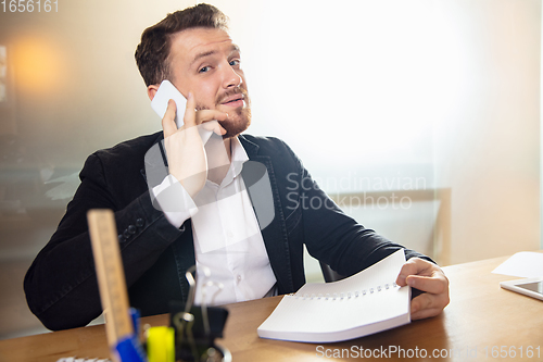 Image of Young man talking, working during videoconference with colleagues at home office